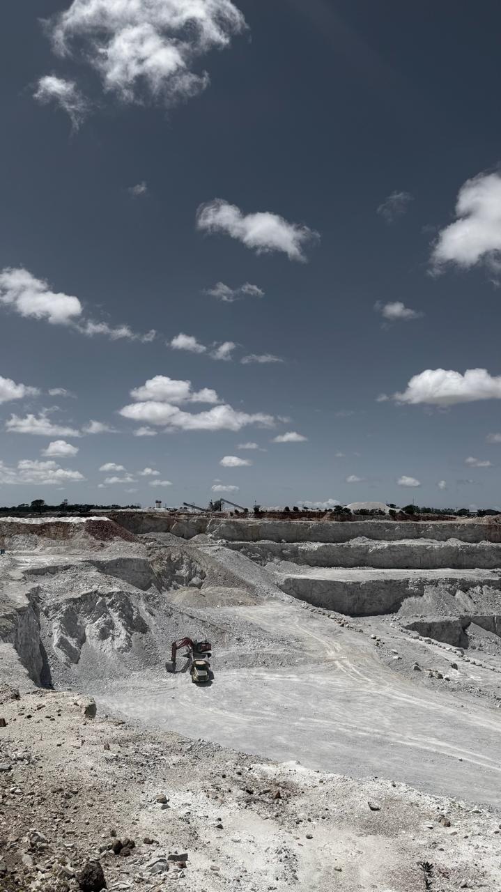 Wide aerial view of CWG Construction open cast quarry with excavator and trucks